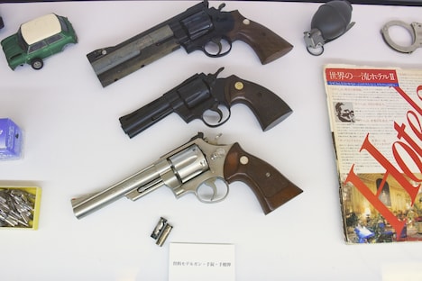 資料用のモデルガン、手錠、手榴弾。