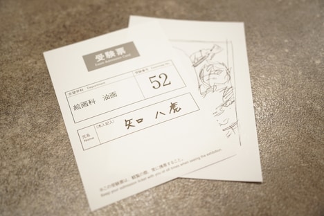 「ブルーピリオド展～アートって、才能か？～」で配られる八虎の受験票とイラスト。