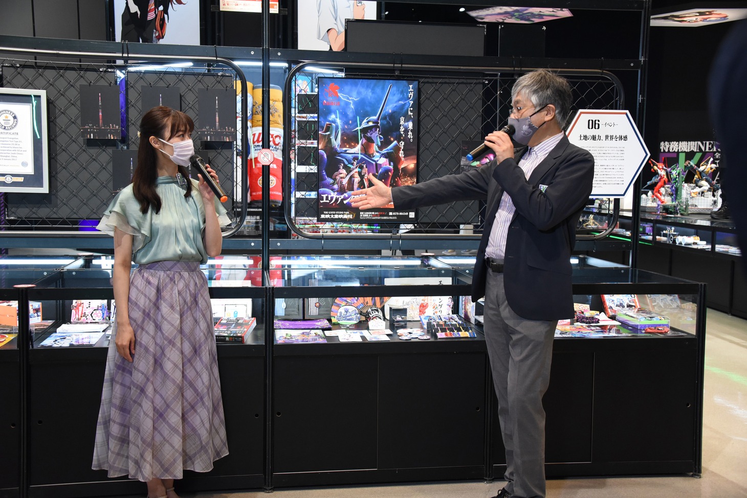 左から展示物の解説を行う野呂陽菜、神村靖宏社長。