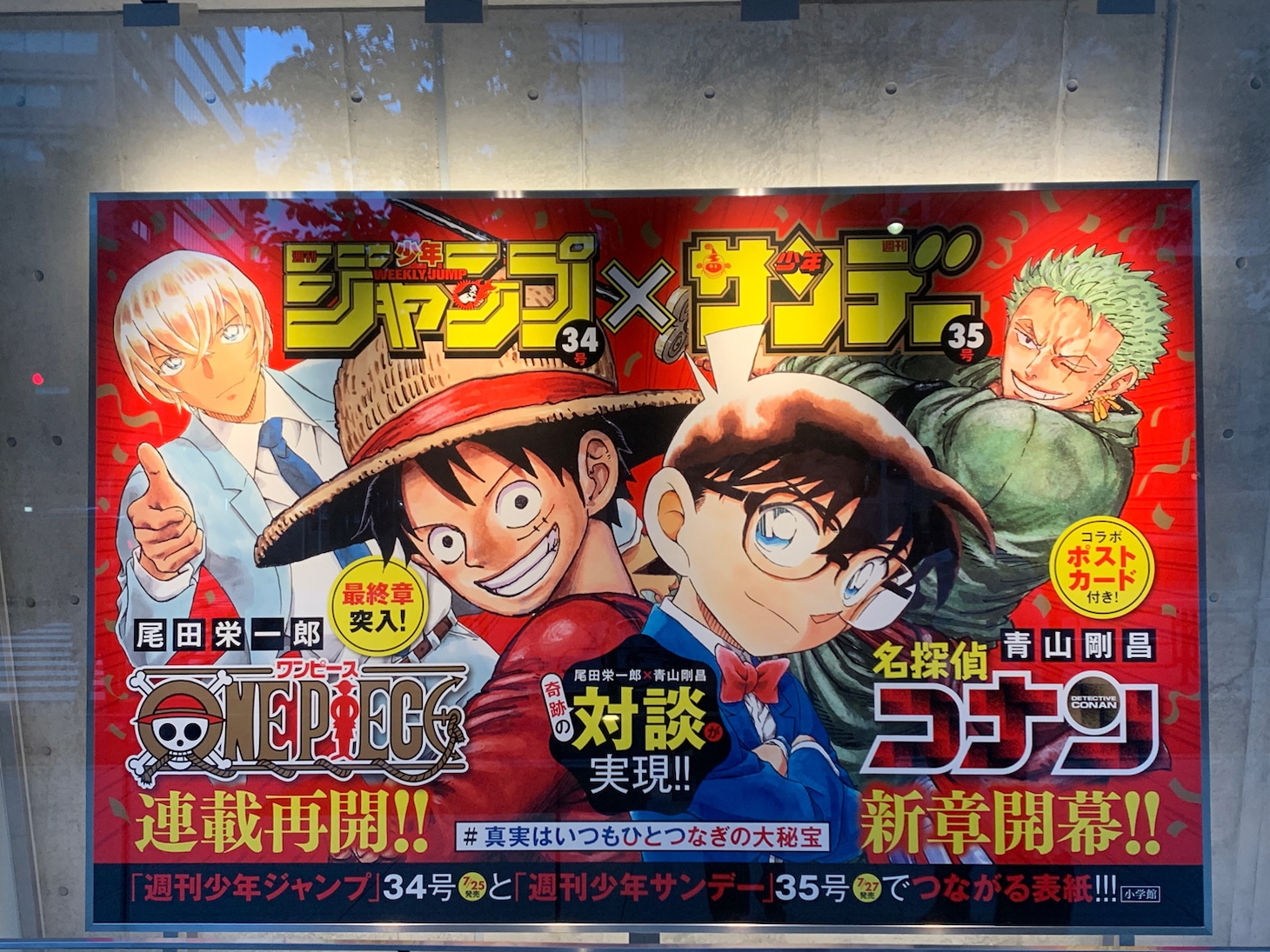 小学館本社ビルに掲出中の巨大パネル。 (c)青山剛昌/小学館 (c)尾田栄一郎/集英社