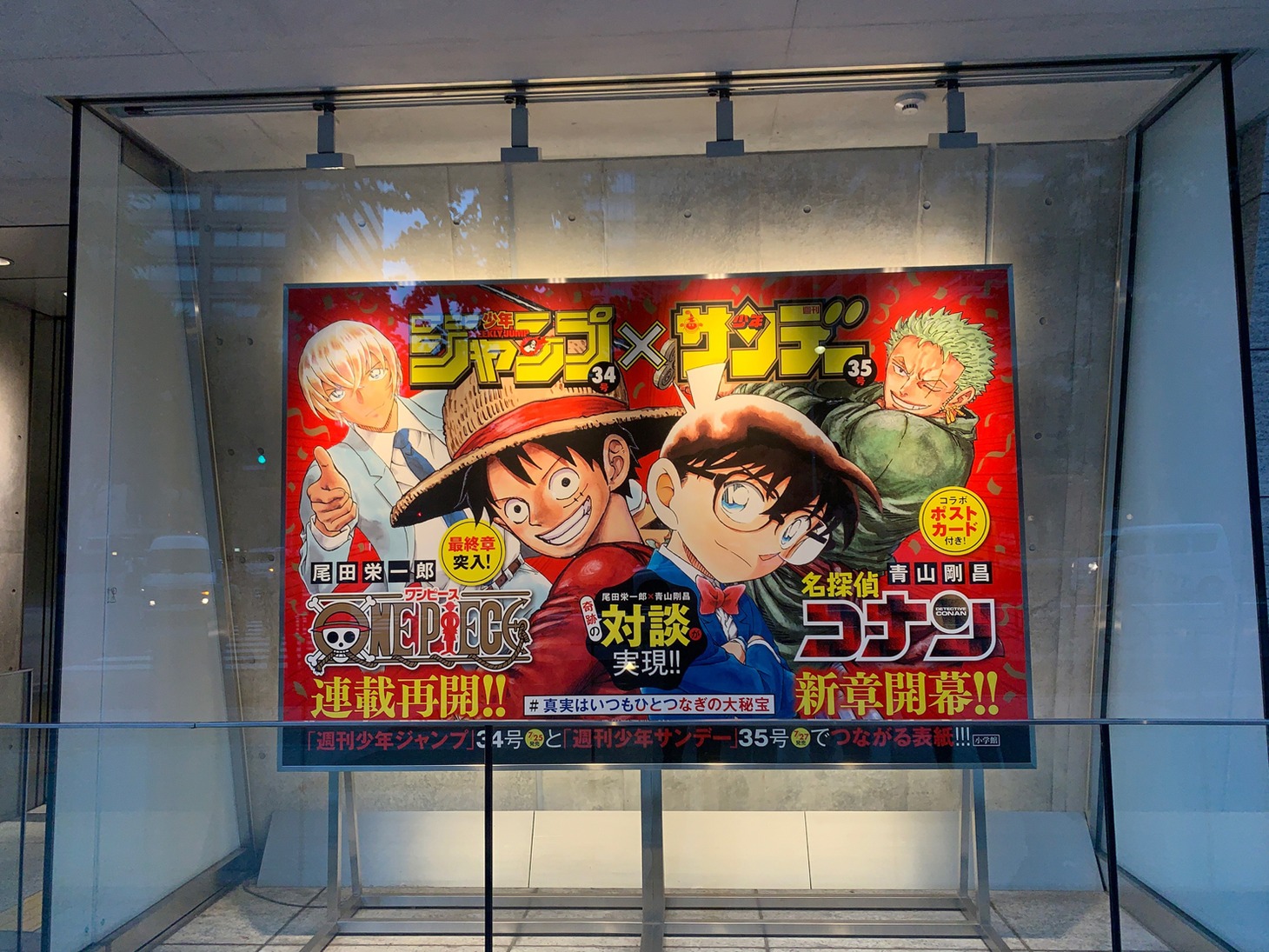 小学館本社ビルに掲出中の巨大パネル。 (c)青山剛昌/小学館 (c)尾田栄一郎/集英社