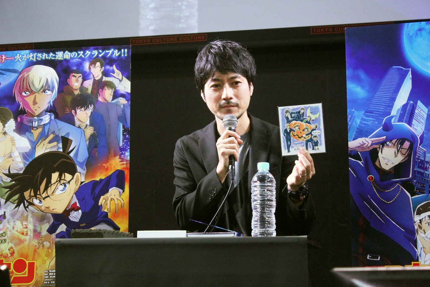 「名探偵コナン ハロウィンの花嫁」の“ハロウィン再会（リバイバル）上映”にて入場者に配布される「青山剛昌先生描き下ろし・ハロウィングリーティングカード」を手にする林原祥一氏。