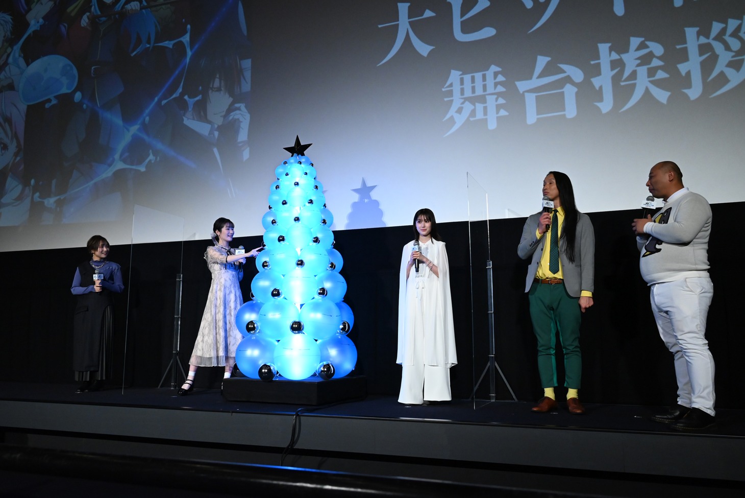 “特大リムル様クリスマスツリー”の弾力を確かめる岡咲美保（左から2人目）。