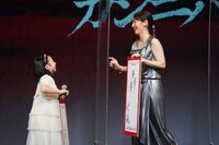 左から志水心音、吉岡里帆。柳楽から受け渡された何かを志水に受け渡している。