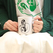 「スカート 222だから実家の猫が嫌そうな顔してる写真置いときますねマグカップ」の使用イメージ。