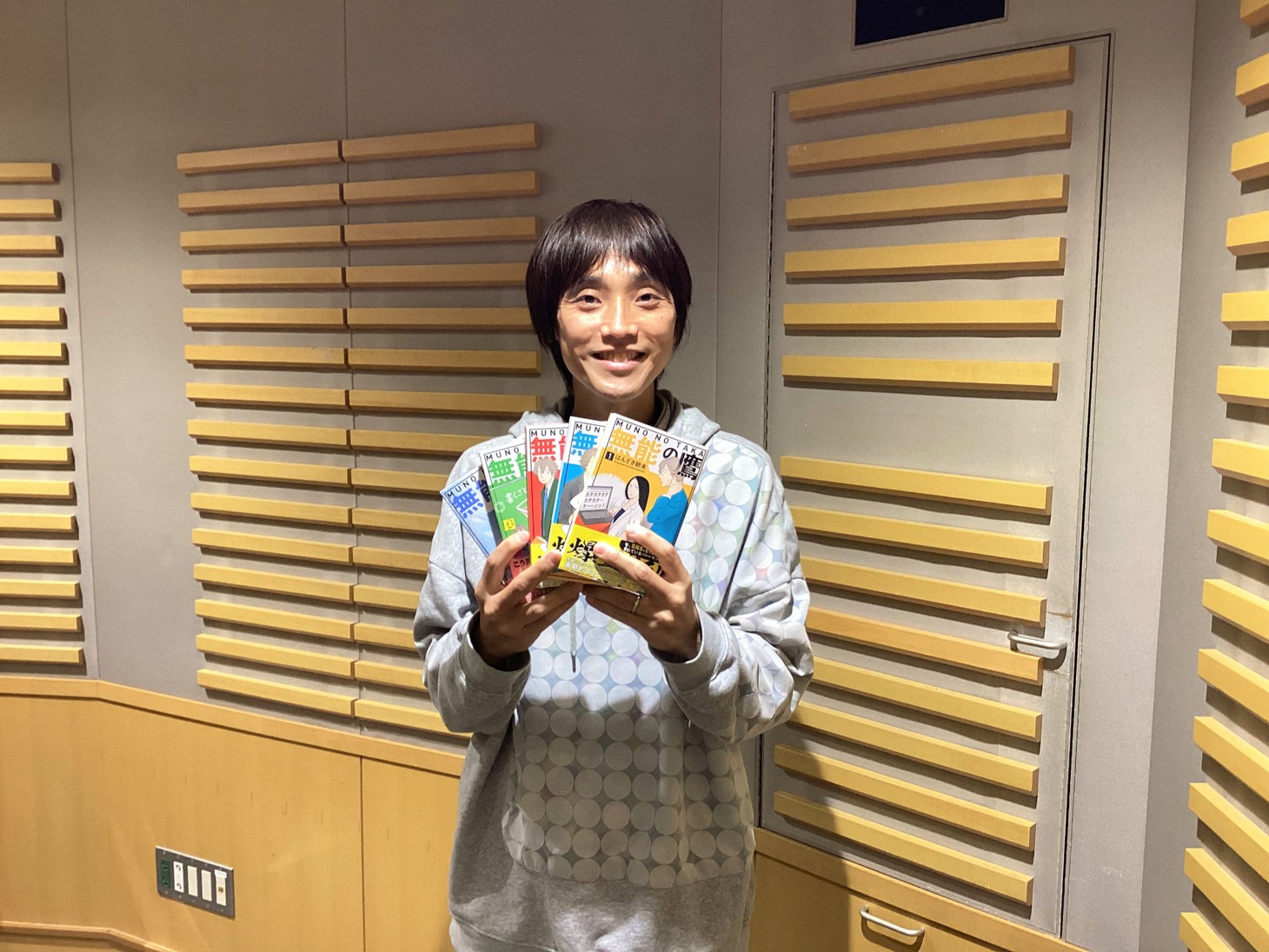 「無能の鷹」の単行本を手に持つ吉田尚記。