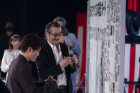 「卒業記念ボード」に書き込む登壇者たち。