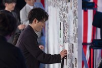 「卒業記念ボード」に書き込む登壇者たち。