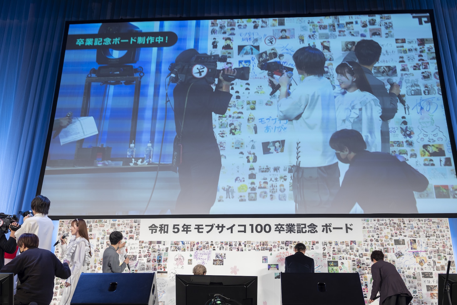 「卒業記念ボード」に書き込む登壇者たち。