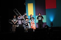 スクリーンに映像が流れる間、司会の天津向を囲む登壇者たち。