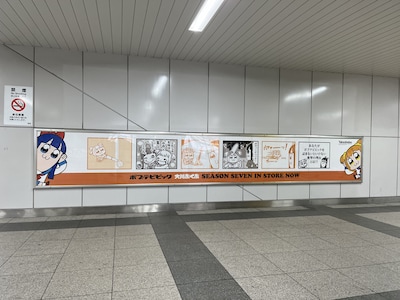 秋葉原駅に登場した「ポプテピピック」の広告。この上に、持ち帰り自由のポストカードが貼られる。
