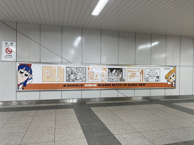 秋葉原駅に登場した「ポプテピピック」の広告。この上に、持ち帰り自由のポストカードが貼られる。