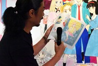 図録からお気に入りのイラストを紹介する菅良太郎。 (c)池野恋／集英社