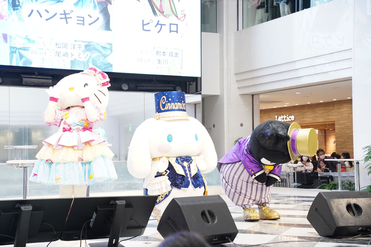 お客さんに挨拶するハローキティ、シナモロール、バッドばつ丸。