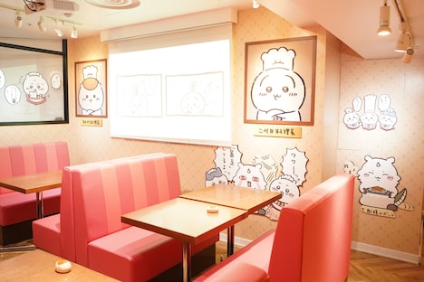 「ちいかわレストラン」店内の様子。奥のスクリーンには原作の「ちいかわ」のコマが映し出されている。