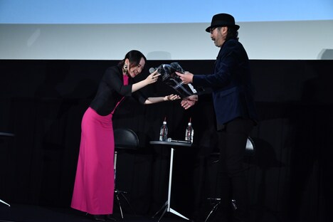 「バトーさん、おめでとう！」と言って大塚明夫（右）に誕生日プレゼントを渡す潘めぐみ（左）。