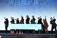 カラオケマイク型のクラッカーを発射する登壇者たち。