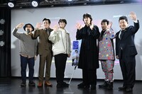 ムービーカメラに向かって手を振る登壇者たち。