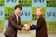 「ホタルの嫁入り」担当編集・森原早苗氏に、トロフィーを渡す炭田真也氏。