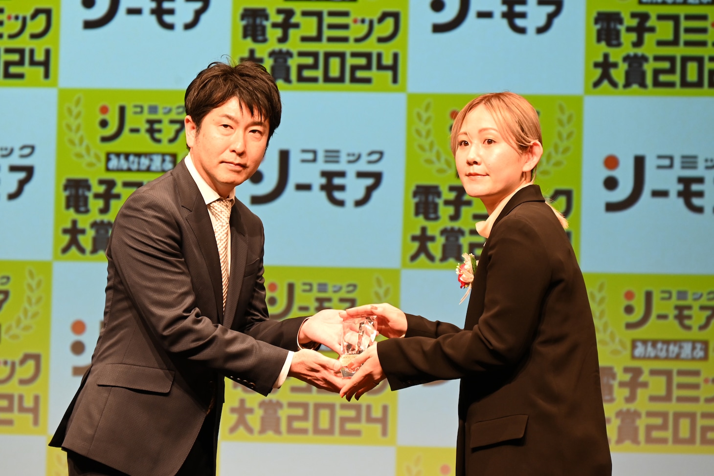 「ホタルの嫁入り」担当編集・森原早苗氏に、トロフィーを渡す炭田真也氏。