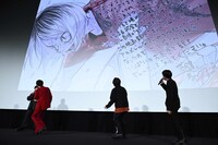 古舘春一からのイラストコメントを見ようとする登壇者たち。