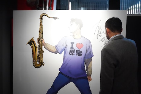 パネルにサインをする石塚真一。