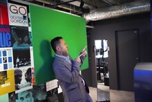 フォトブースで写真撮影を体験する石塚真一。