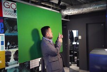 フォトブースで写真撮影を体験する石塚真一。