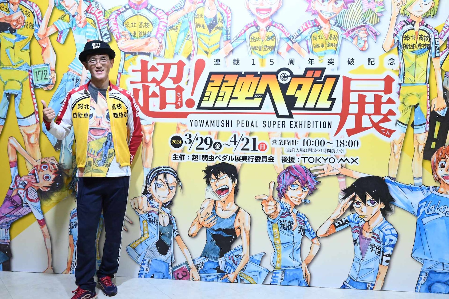 「超！弱虫ペダル展」のビジュアルの前に立つ渡辺航。