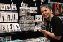 一日店長として店内のグッズをおすすめする福西勝也。