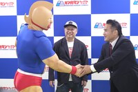 キン肉マンと握手する嶋田隆司。