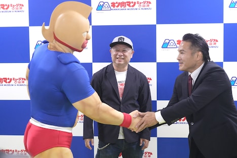 キン肉マンと握手する嶋田隆司。