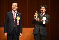 坂上暁仁（右）の贈呈式の様子。