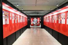 「『キン肉マン』愛と絆の原画展」の様子。ゆでたまごの年表が貼られた通路。