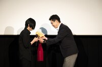 みきゃんのぬいぐるみを受け取る櫻木優平監督。