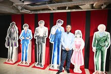 「Kの系譜」の内覧会にて、等身大パネルとともに撮影する真船一雄。 (c)真船一雄／講談社