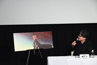 アニメ映画「果てしなきスカーレット」のビジュアルについて説明する細田守監督。