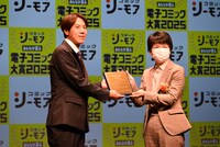 「華麗に離縁してみせますわ！」の原作者・白之いちじくが表彰盾を受け取る様子。