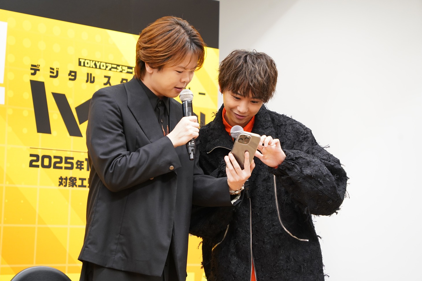 「TOKYOアニメツーリズム2025」専用のスマホアプリを操作する村瀬歩、須賀健太。