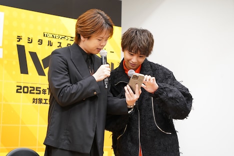 「TOKYOアニメツーリズム2025」専用のスマホアプリを操作する村瀬歩、須賀健太。