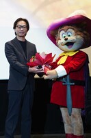 ペロから花束を渡される西川和宏プロデューサー。