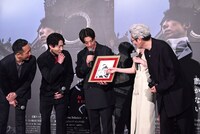 荒木飛呂彦の描き下ろしイラストを見ようとする登壇者たち