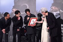 荒木飛呂彦の描き下ろしイラストを見ようとする登壇者たち