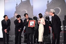 荒木飛呂彦の描き下ろしイラストを見ようとする登壇者たち