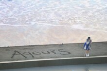 砂浜に「Aqours」の文字を書く小宮有紗