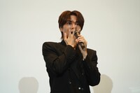 口に手を当てる八代拓