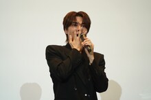 口に手を当てる八代拓