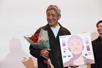 花束とイラストで74歳の誕生日を祝われる小林薫。