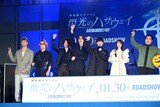 左から[Alexandros]リアド偉武、白井眞輝、磯部寛之、川上洋平、小野賢章、上田麗奈、松井ケムリ。ムービーカメラに手を振る様子