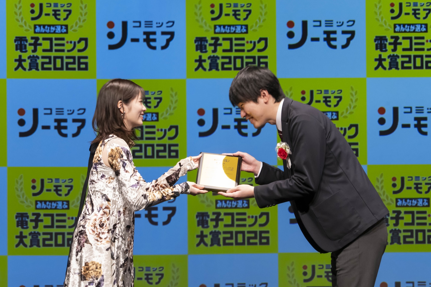 女性部門受賞作「ベル・プペーのスパダリ婚約～『好みじゃない』と言われた人形姫、我慢をやめたら皇子がデレデレになった。実に愛い！～」の授賞シーン。右はスクウェア・エニックスの辰井宏城